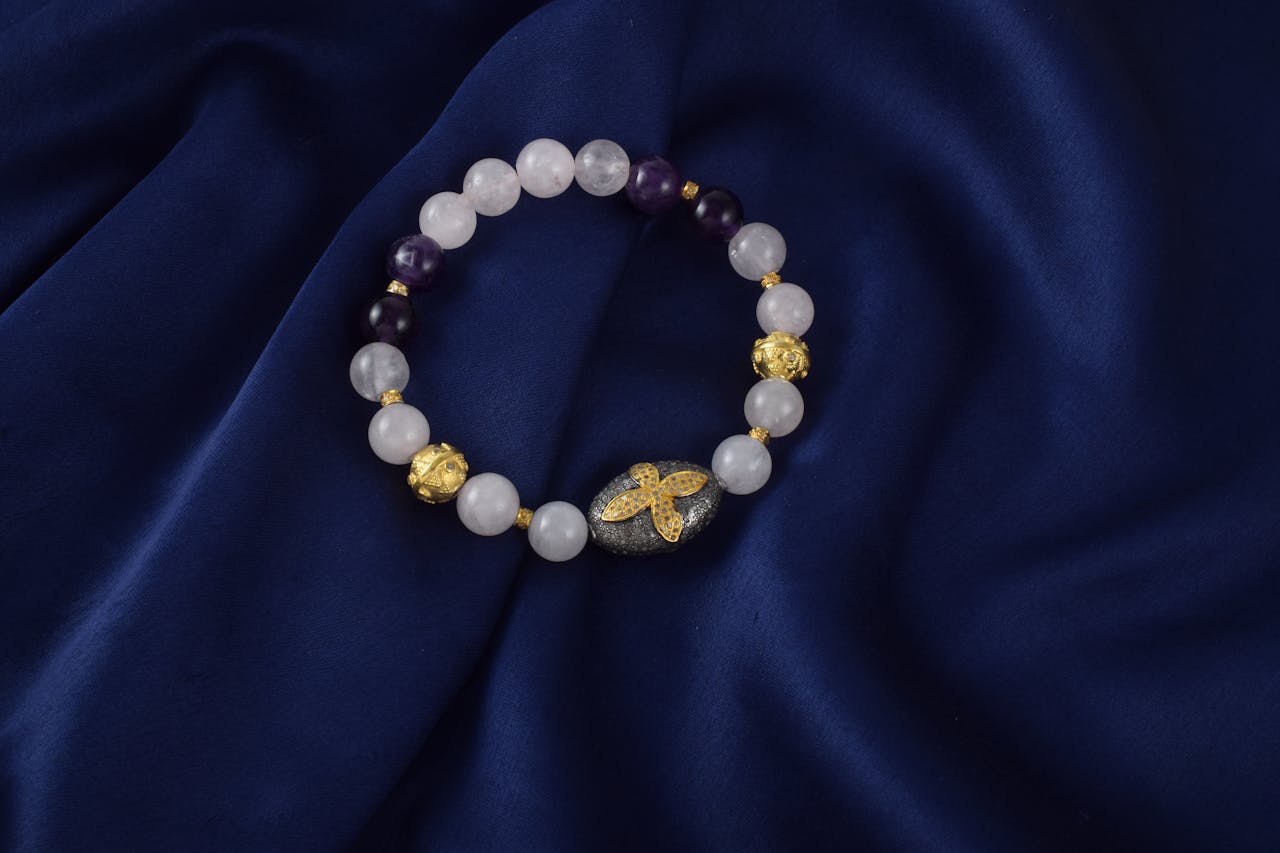 Close-up of a beaded bracelet with gemstones on navy fabric background.